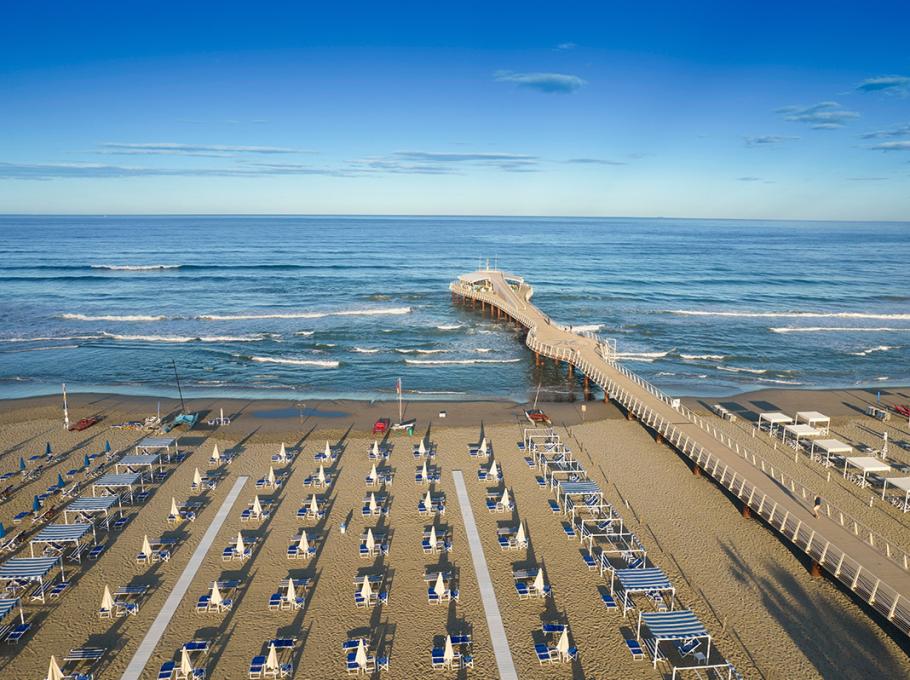 Scogliere e barche in un mare cristallino con spiaggia nascosta.